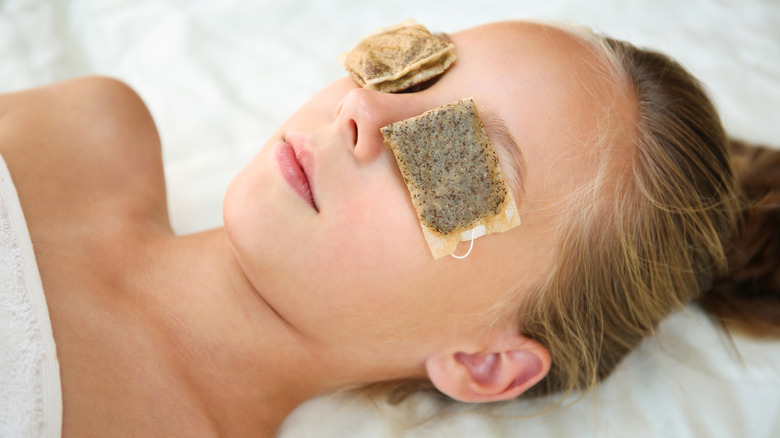 Woman with tea bags on her eyes