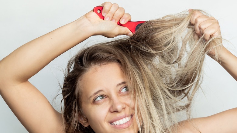 Woman combing bleached hair