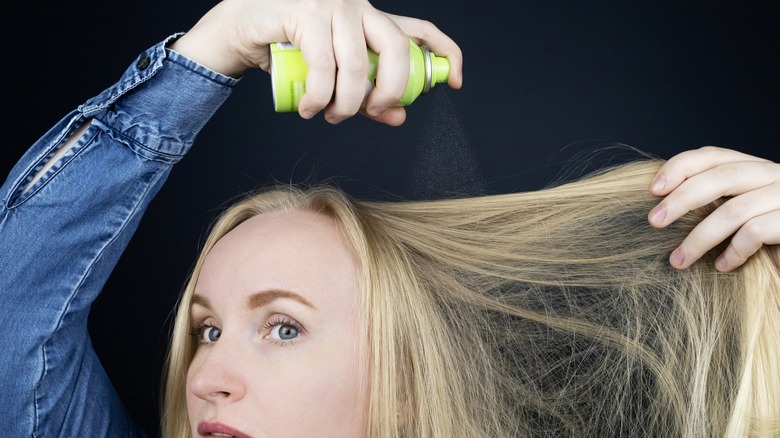 Woman spraying hair product