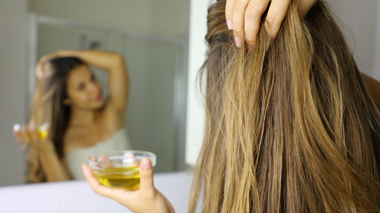 Woman applying hair oil