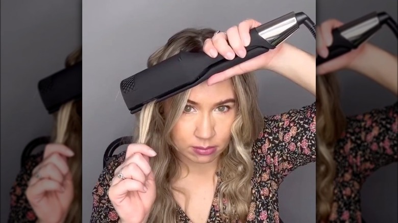 Woman using single-waver hair tool 