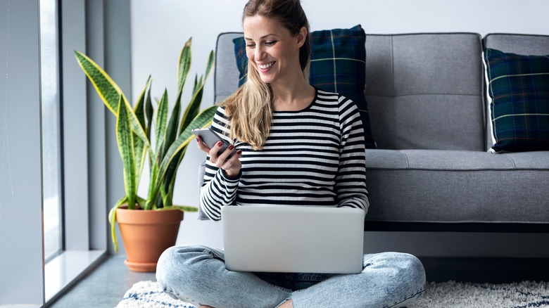 Woman working while sitting on the floor