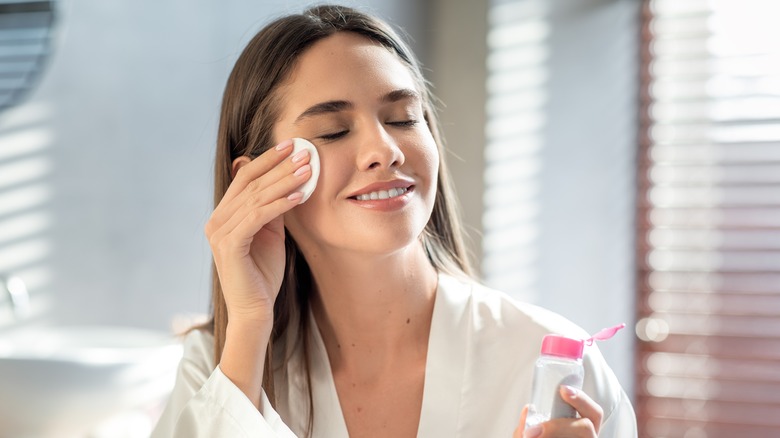 Woman applying toner to face