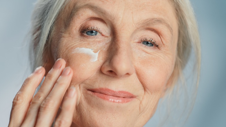 A woman using eye cream. 