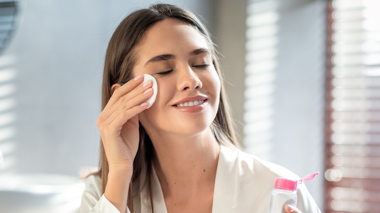 A woman applying skincare products