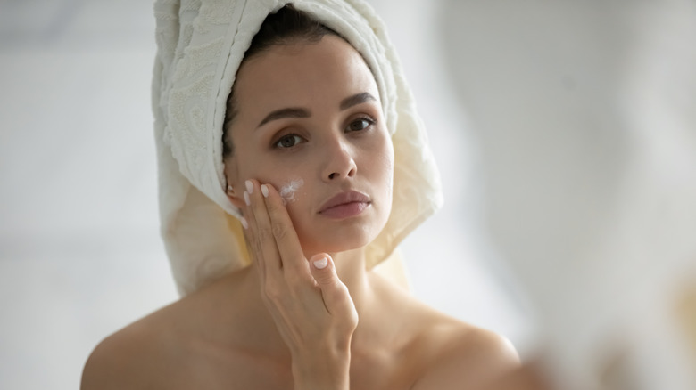 Woman putting moisturizer on her face