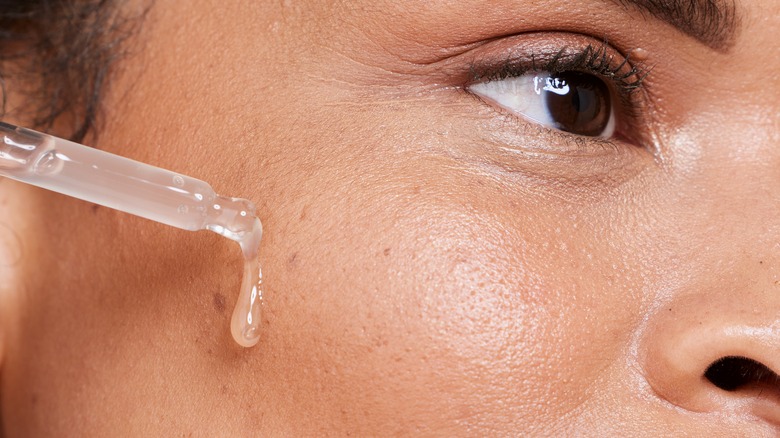 A woman applying a serum