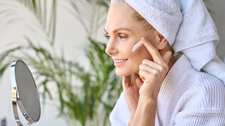 Older woman applying face cream
