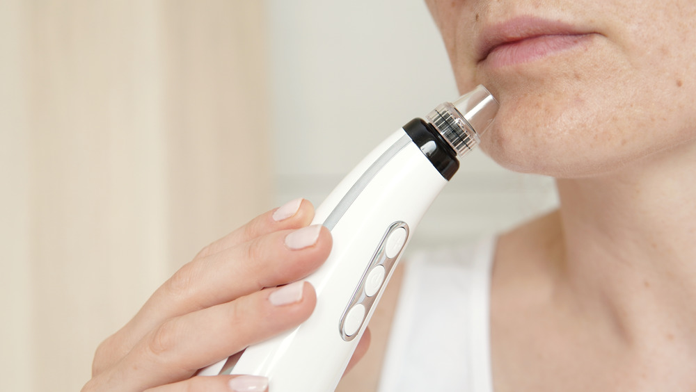 A woman using a pore vacuum