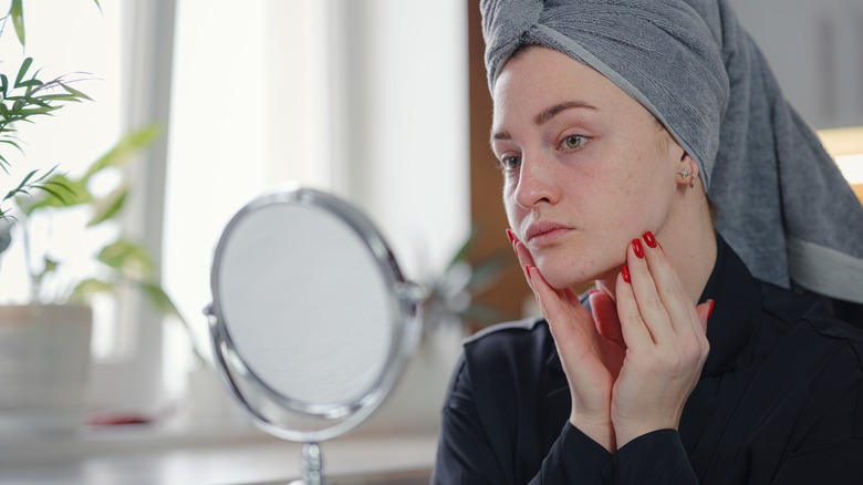 Worried woman checking her skin