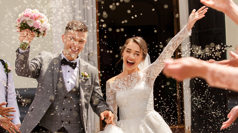 guests throwing rice at a couple on their wedding day