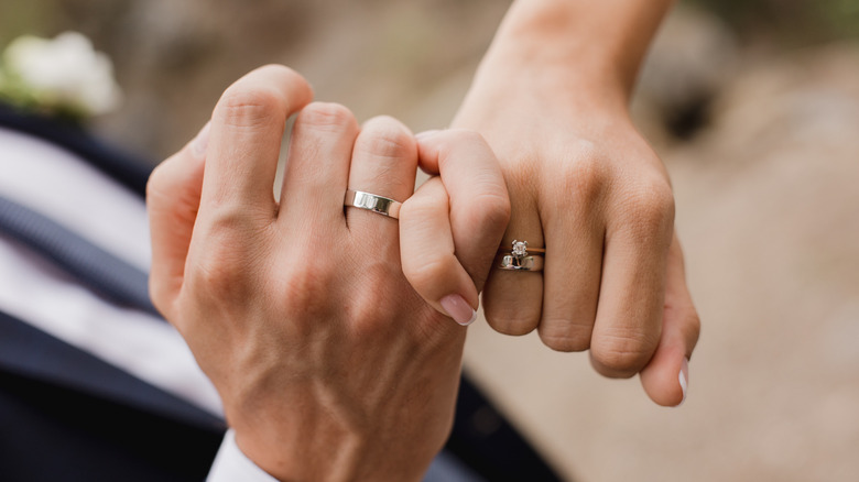 a couple's hands with their wedding rings