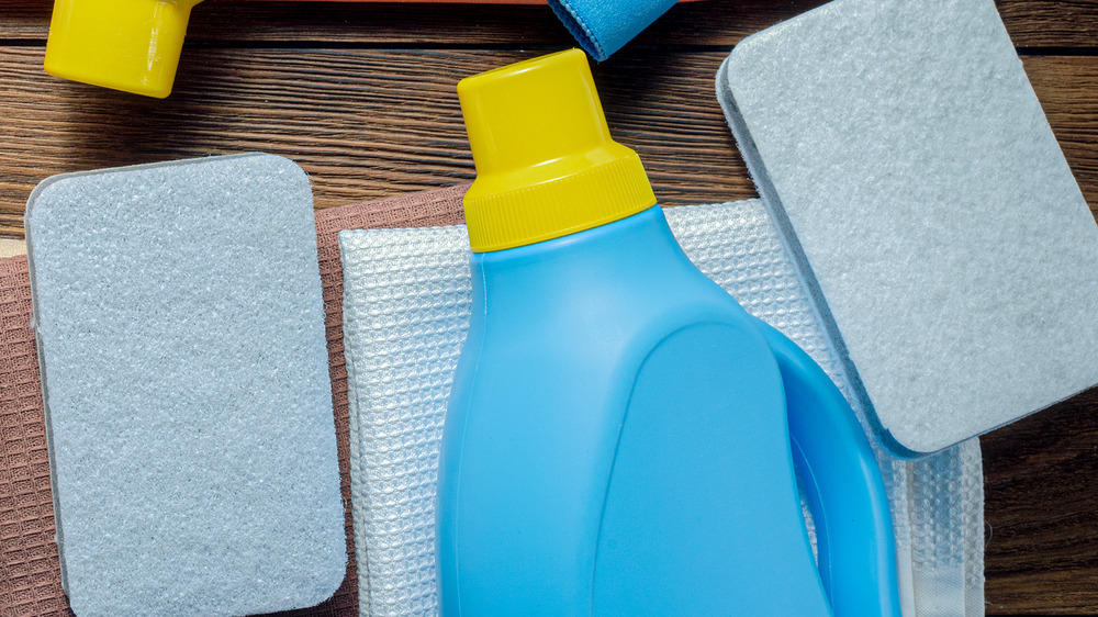 Blue sponges next to a detergent bottle