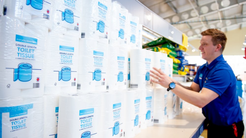 Worker stocking shelves in Aldi