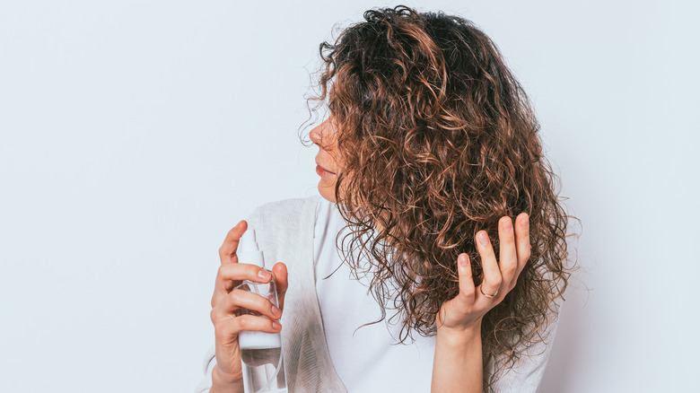 Woman spraying curly hair