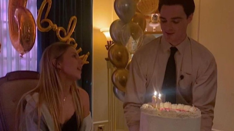 Jacob Elordi presenting Romy Mars with a birthday cake