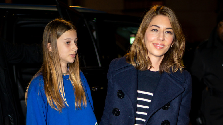 Romy Mars and Sofia Coppola standing beside a car