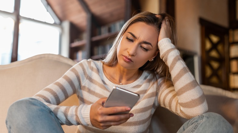 upset woman looking at her phone