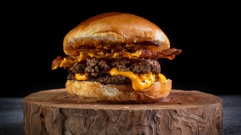 bacon cheese burger center, black background