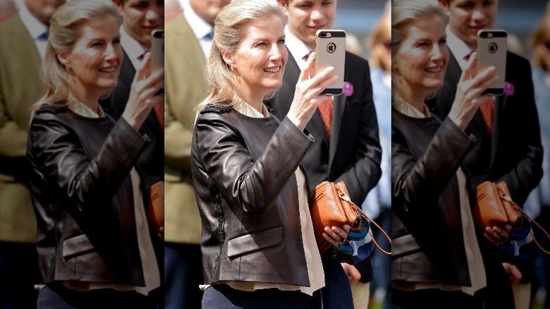 Countess of Wessex in leather jacket taking a photo