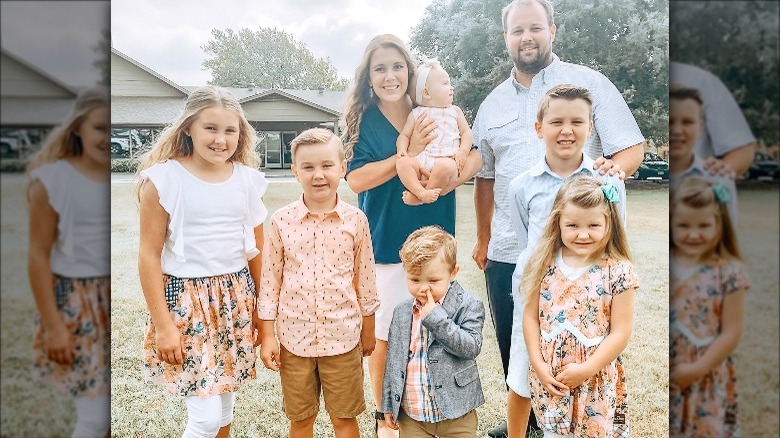 Anna and Josh Duggar standing with their seven children