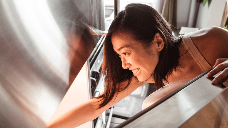 woman reaching into freezer