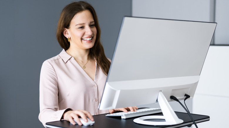 Woman smiling at standing desk