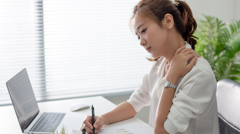 woman holding her neck in pain