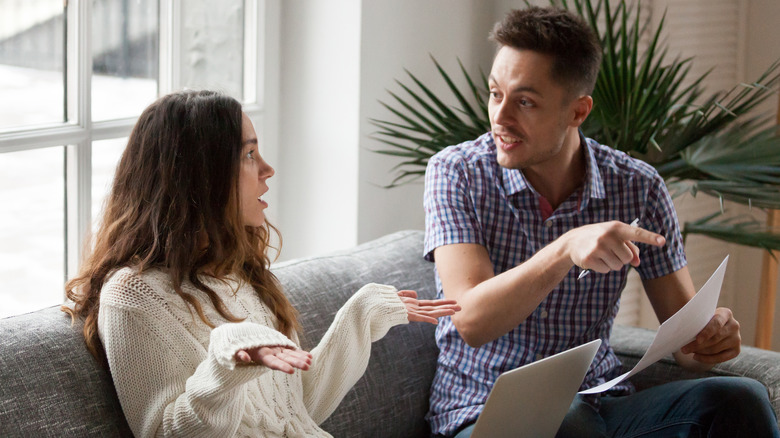 stressed couple talking on couch