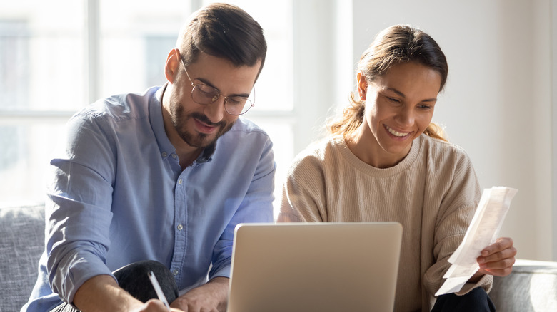 smiling couple working on laptop