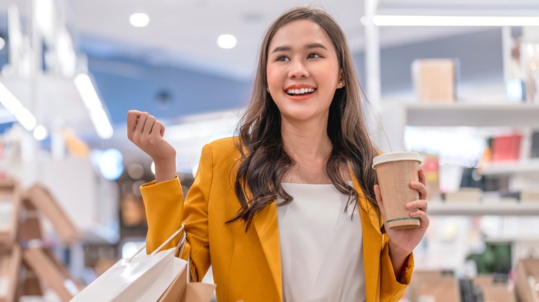 smiling woman holding coffee shopping