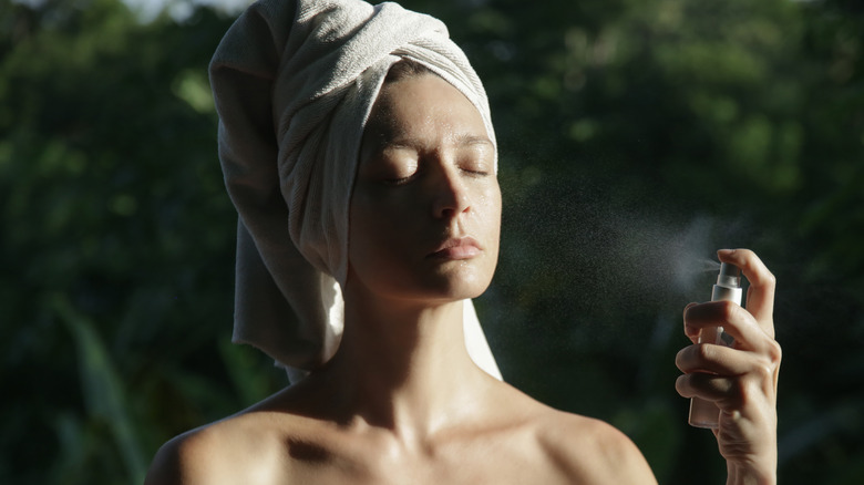 Woman using spray-on skincare