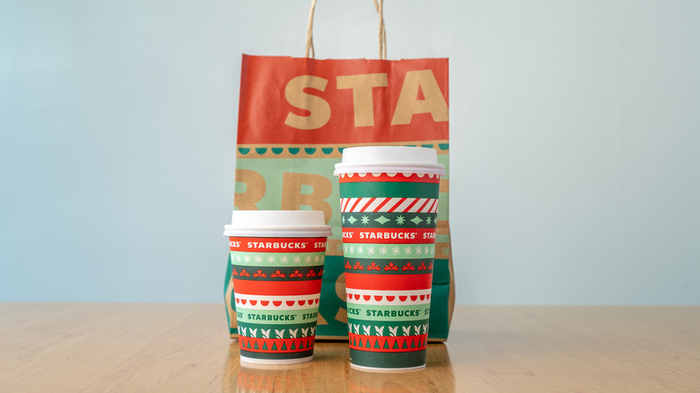 Two holiday-themed Starbucks to-go cups 