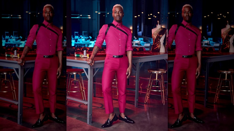 Sha'Vi Lewis poses in pink suit in his fashion studio