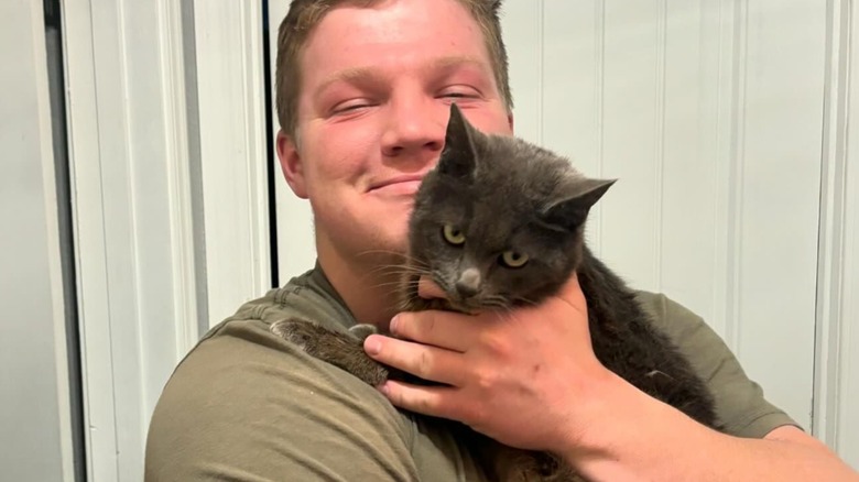 Garrison Brown holding cat, smiling