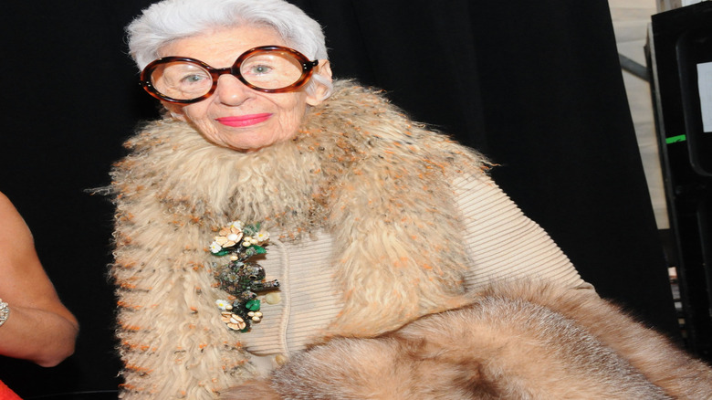 Iris Apfel in trademark glasses and fuzzy boa