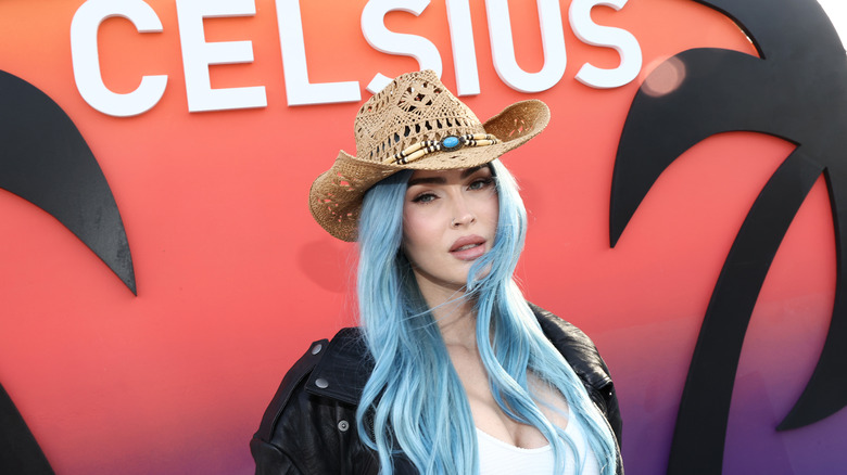 Megan Fox posing with blue hair in a cowboy hat