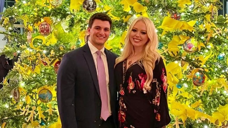 Tiffany Trump and Michael Boulos posing in front of a Christmas tree