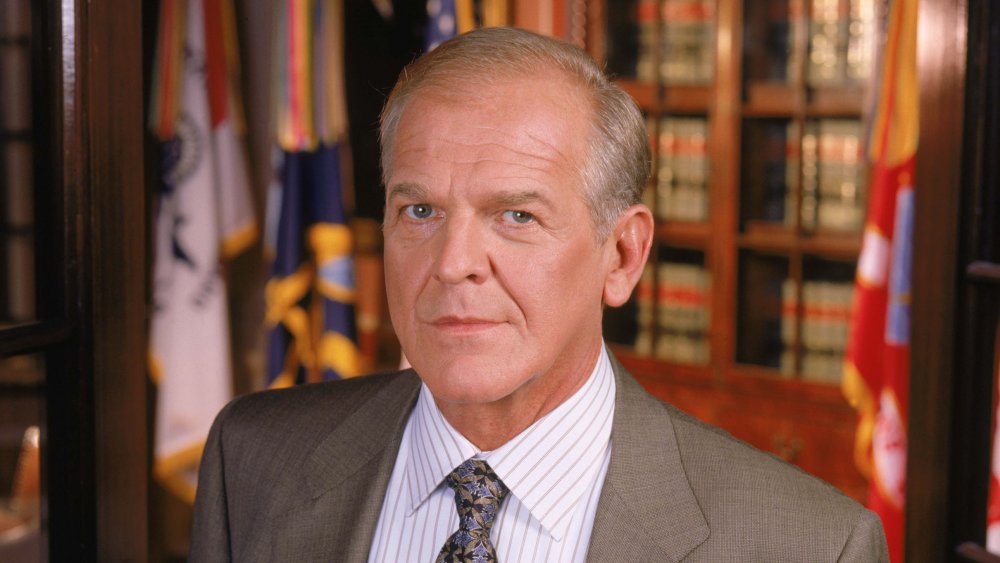 John Spencer standing in front of law books