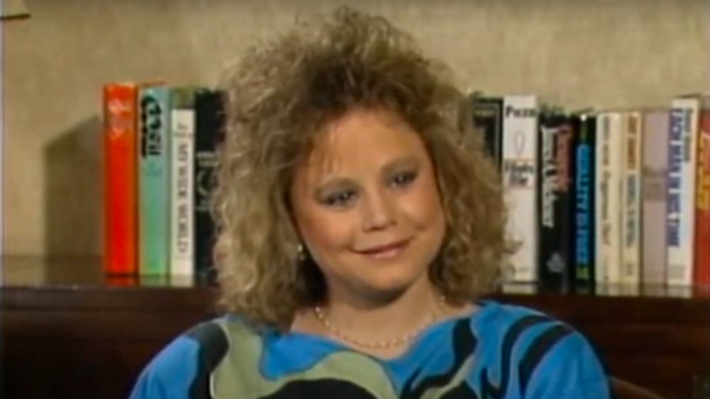 Dana Hill sitting in front of a row of books