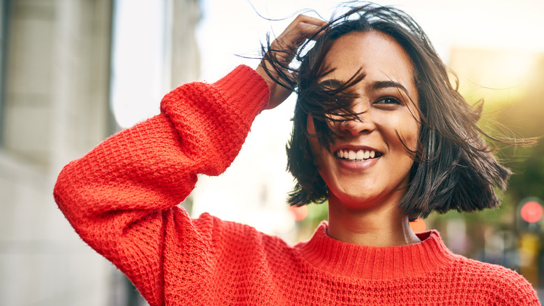 Woman smiling in orange sweater