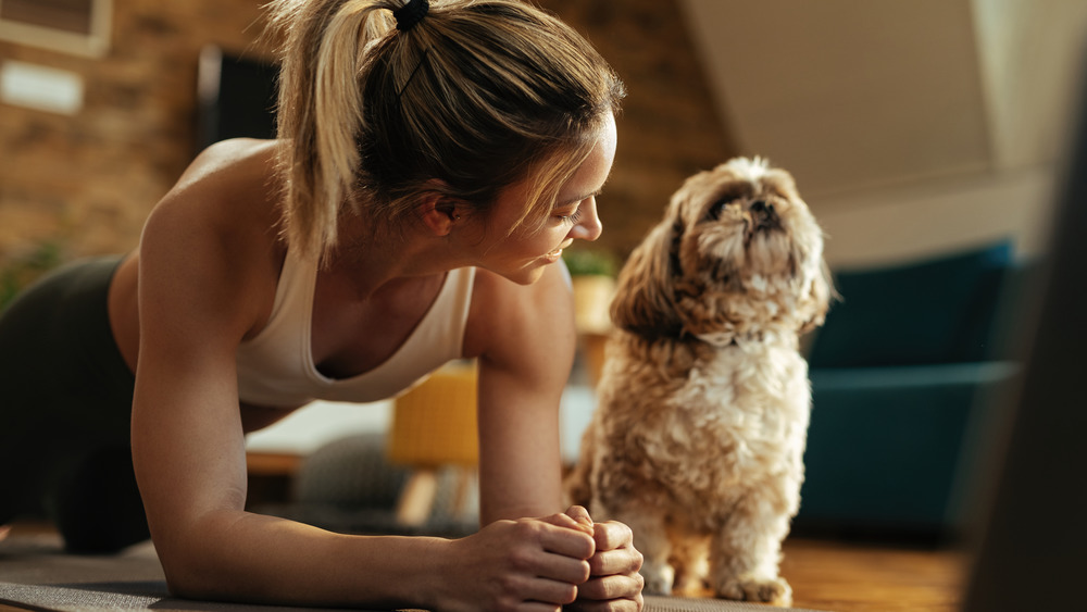 A woman planking next to her dog