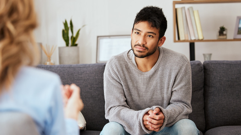 man talking with a therapist on a couch