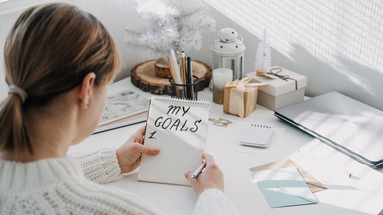 woman writing down her goals on paper