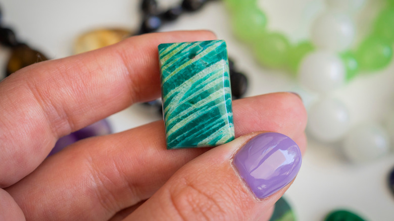 A person holding an Amazonite stone.