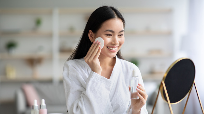 Woman using makeup remover pad on cheek