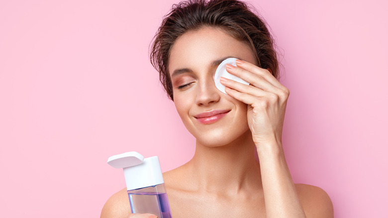 Woman using makeup pad on eye