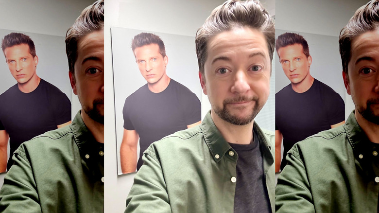 General Hospital's Bradford Anderson posing in front of a Steve Burton picture