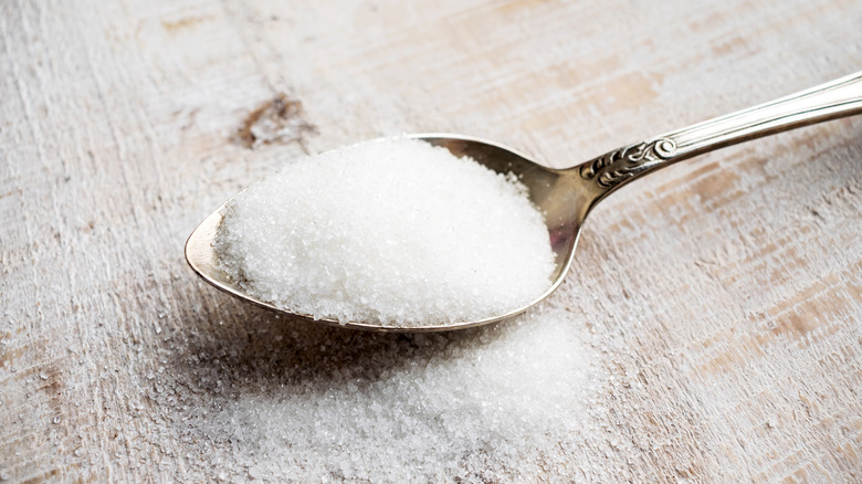 Spoon filled with white granules