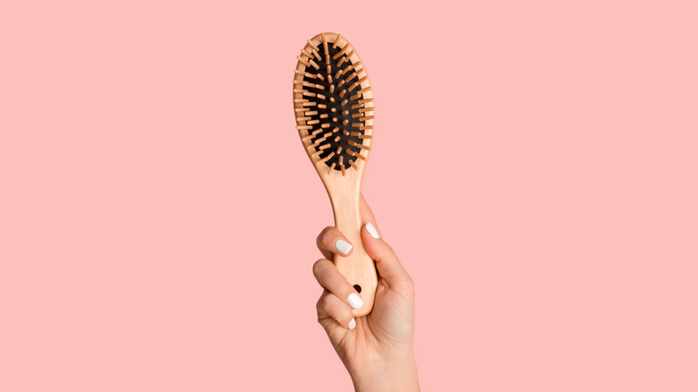 Female hand holding hairbrush